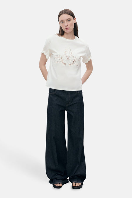 Wit T-shirt met korte mouwen van MANGO, met bloemenkanten detail aan de voorkant, gedragen met een wijde jeans.