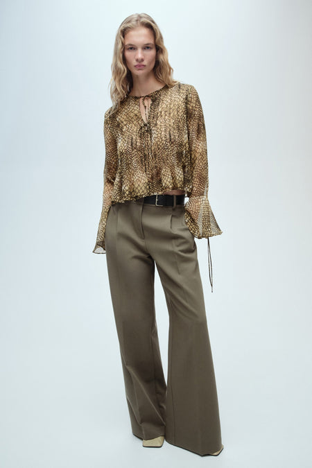 Bruine blouse met lange mouwen van MANGO, met slangenprint en olijfgroene broek met hoge taille.