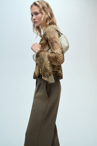 Bruine blouse met lange mouwen van MANGO, slangenprint, gedragen met een olijfgroene broek.