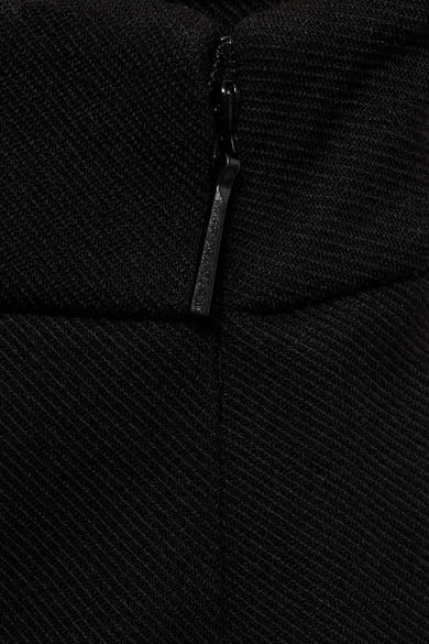 Zwarte broek van MANGO, textuurdetail van de stof met zichtbare ritssluiting.