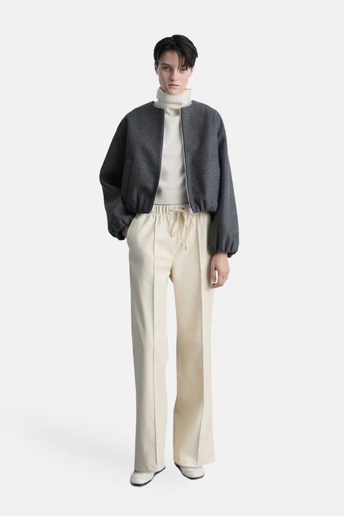 Blazer gris by MANGO, porté sur un pull à col roulé écru et un pantalon taille haute beige.