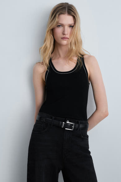 Zwart hemdje van MANGO, met contrasterende witte bies, gedragen met een zwarte jeans met bijpassende riem.