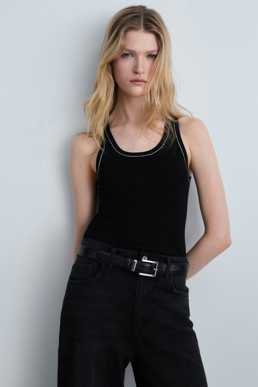 Zwart hemdje van MANGO, met contrasterende witte bies, gedragen met een zwarte jeans met bijpassende riem.