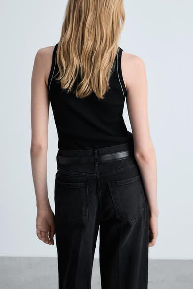 Zwart MANGO hemdje met witte biesjes, gedragen met een zwarte jeans en een leren riem.