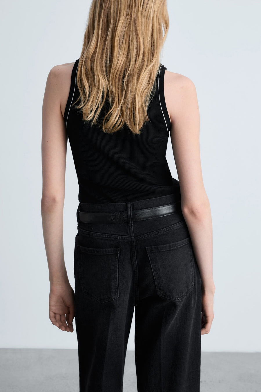 Zwart MANGO hemdje met witte biesjes, gedragen met een zwarte jeans en een leren riem.