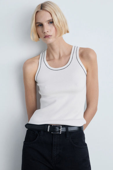 Witte tanktop van MANGO, met zwarte randen op de kragen en mouwen, gedragen met een zwarte jeans en zwarte laarzen, achterzicht.