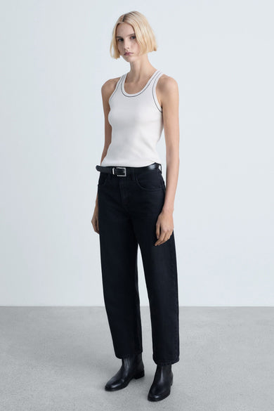 Witte tanktop van MANGO met zwarte contrasteerende naaigaten, gedragen met een hoge taille zwarte en enens.