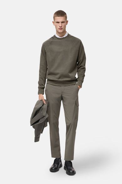 Sweat kaki par MANGO, porté avec une chemise blanche et un pantalon cargo assorti, tenue décontractée.