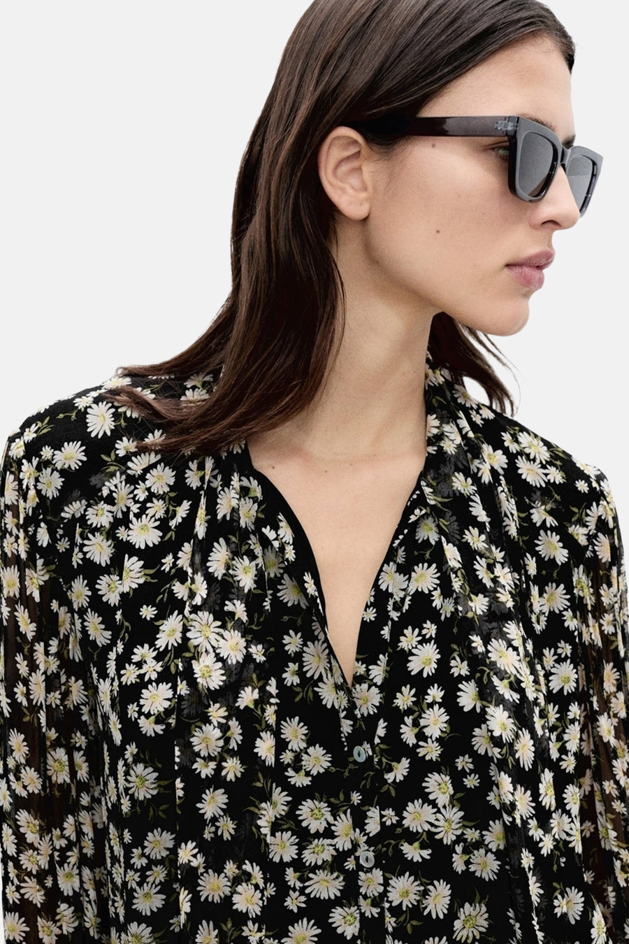 Zwarte blouse met lange mouwen van MANGO, met madeliefjesprint, gedragen met een zwarte zonnebril.