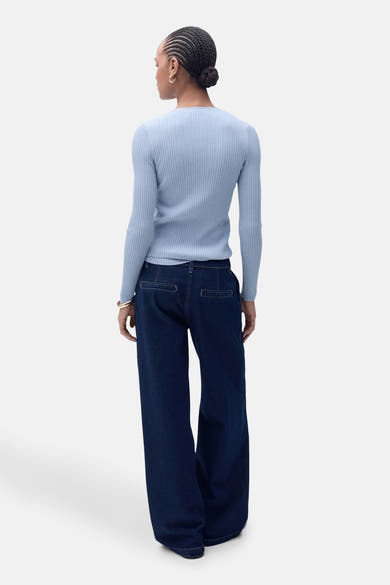 Blauwe geribbelde cardigan van MANGO, gedragen met een wijde spijkerbroek met hoge taille, achtergezicht.