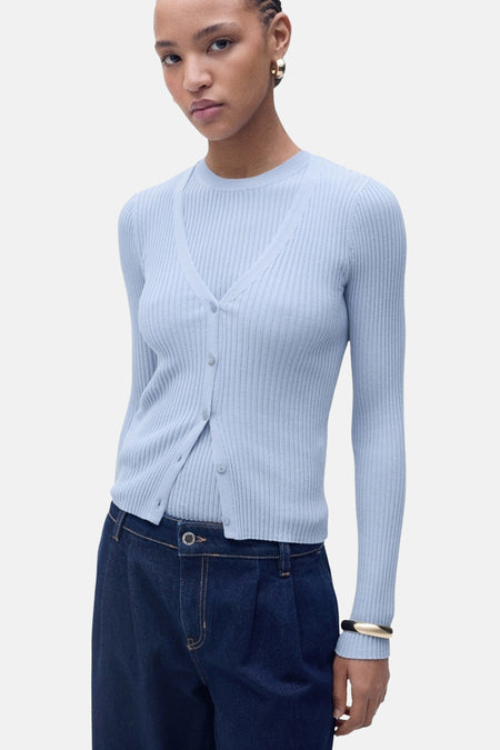 Blauwe geribbelde cardigan van MANGO, gedragen met een bijpassend blauw T-shirt en een donkerblauwe spijkerbroek met hoge taille.