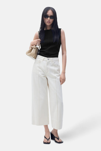 Zwart hemdje van MANGO, gedragen met een witte high-waist jeans en zwarte sleehakken.