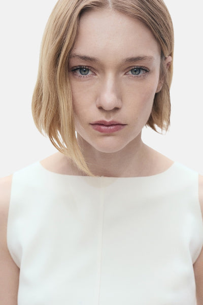 Débardeur écru de MANGO, uni et sans manches, porté par un mannequin aux cheveux blonds courts.
