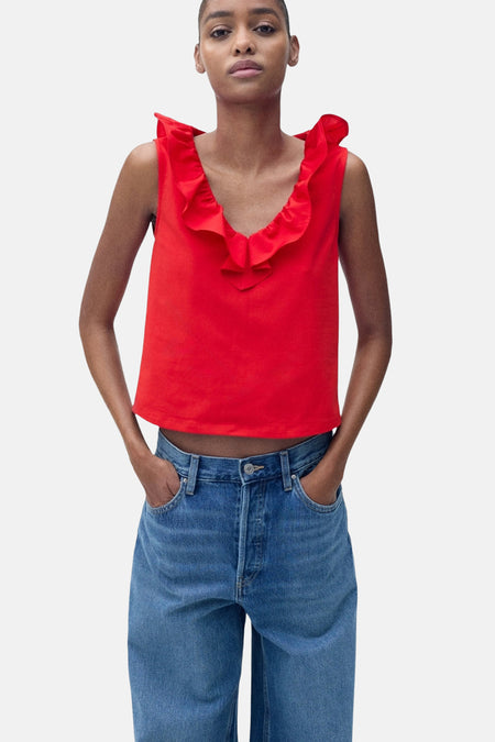 Rood mouwloos topje van MANGO, met rode ruche op de kraag, gedragen met een wijde high-waisted jeans.