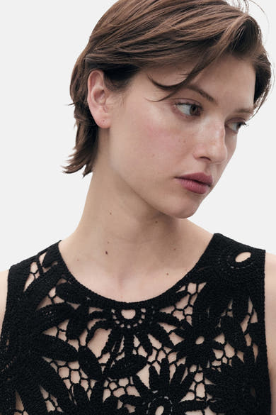 Zwarte mouwloze blouse van MANGO met bloemenhaakpatroon.