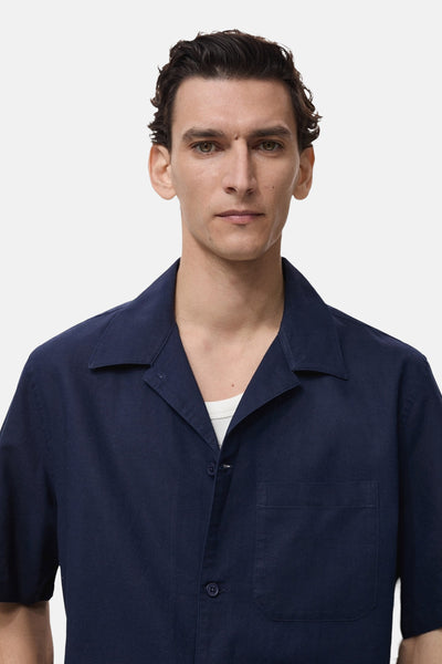 Chemise bleue à manches courtes de MANGO, avec col ouvert et poche poitrine.
