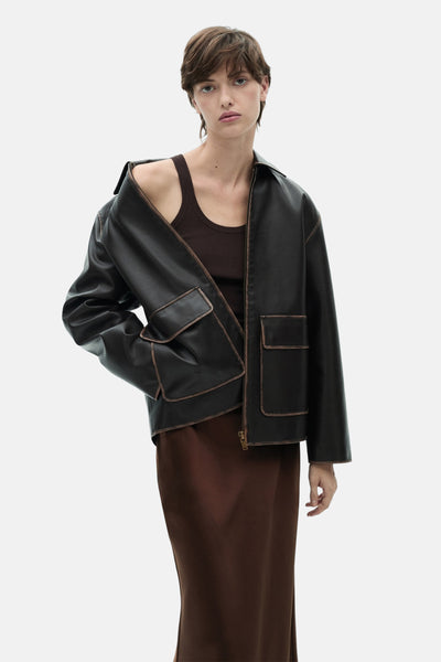 Lange bruine rok van MANGO, gedragen met een leren jasje en een bruine top.