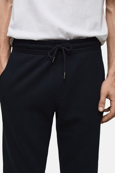 Blauwe joggingbroek van MANGO, met trekkoord in de taille en zijzakken, gedragen met een wit T-shirt.