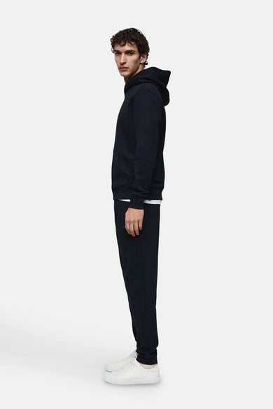 Blauwe joggingbroek van MANGO, gedragen met een wit T-shirt en witte sneakers, in zijaanzicht.
