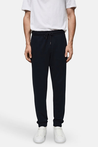 Jogging bleu par MANGO, avec cordon de serrage et portées avec un t-shirt blanc et des baskets blanches.