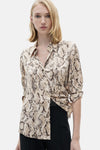 Bruine blouse met lange mouwen van MANGO, met slangenprint, gedragen met een zwarte broek.
