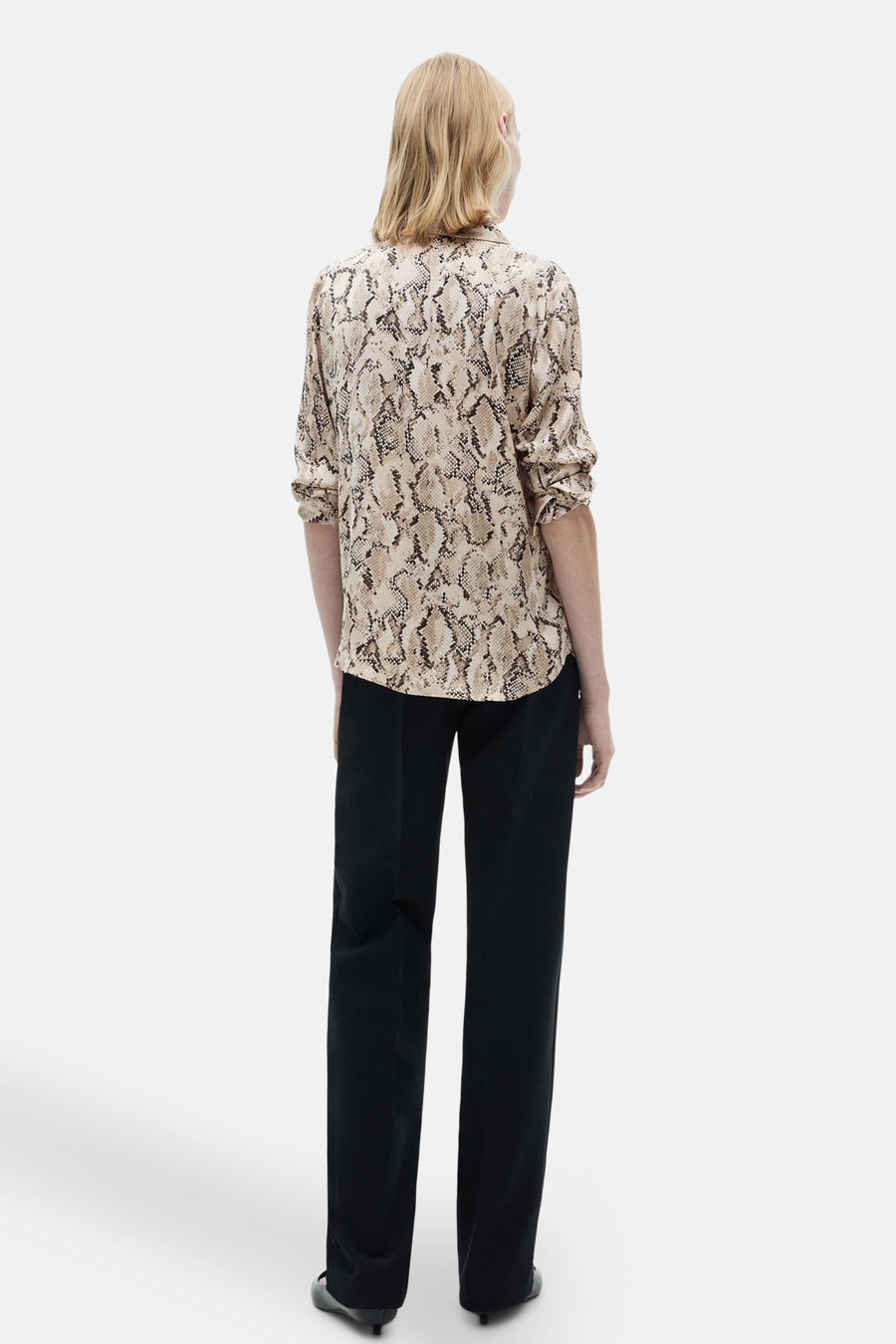 Chemisier à manches longues brun de MANGO, avec motif peau de serpent, porté avec un pantalon noir.
