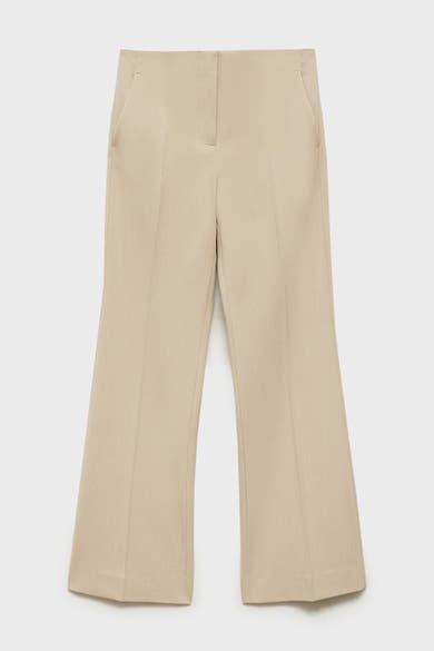 Pantalon de costume beige de MANGO, avec une coupe évasée et des poches latérales discrètes.
