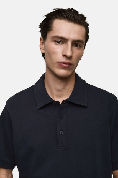 Polo bleu foncé de MANGO, coupe classique avec col et patte de boutonnage, porté par un homme.