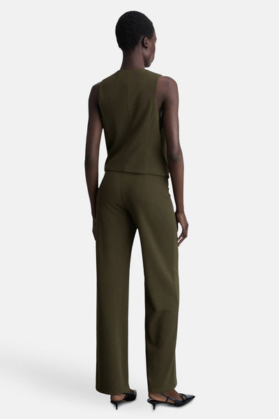 Kaki broek van MANGO, rechte pasvorm en wijde pijpen, gedragen met zwarte pumps.