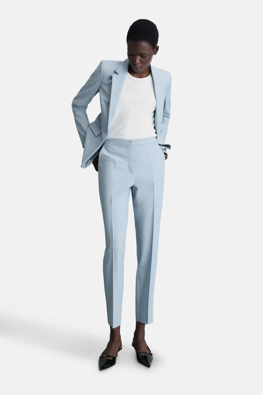 Lichtblauwe pantalon van MANGO, gedragen met een bijpassend colbert en een wit T-shirt.
