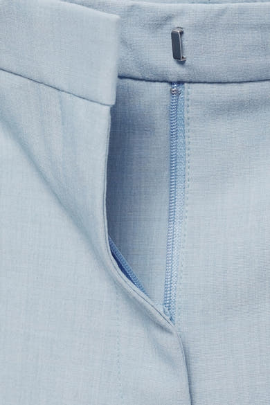 Lichtblauwe pantalon van MANGO, met een zichtbare ritssluiting en een subtiele textuur.