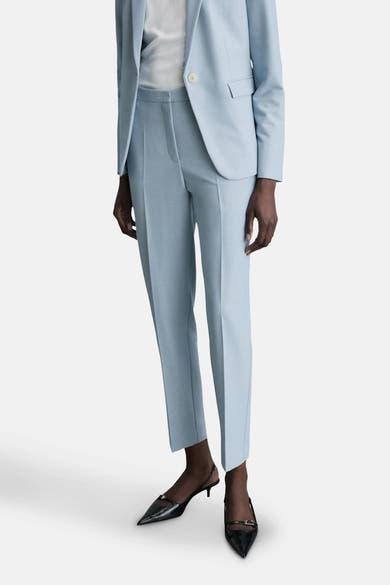 Lichtblauwe pantalon van MANGO, gedragen met een bijpassende blazer en zwarte puntige pumps.