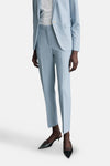Lichtblauwe pantalon van MANGO, gedragen met een bijpassende blazer en zwarte puntige pumps.