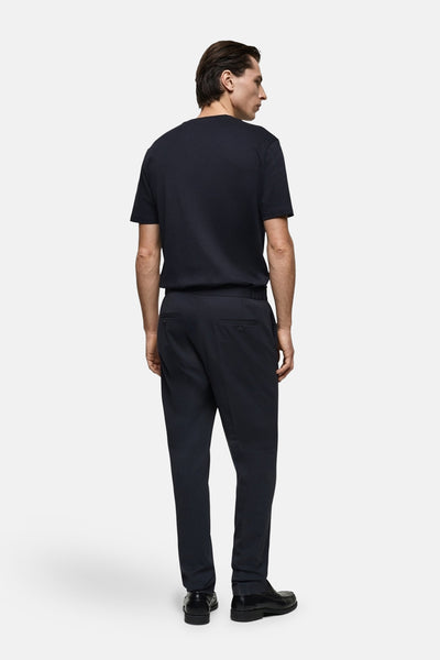 T-shirt à manches courtes bleu foncé de MANGO, porté avec un pantalon assorti et des chaussures en cuir noir, vue de dos.