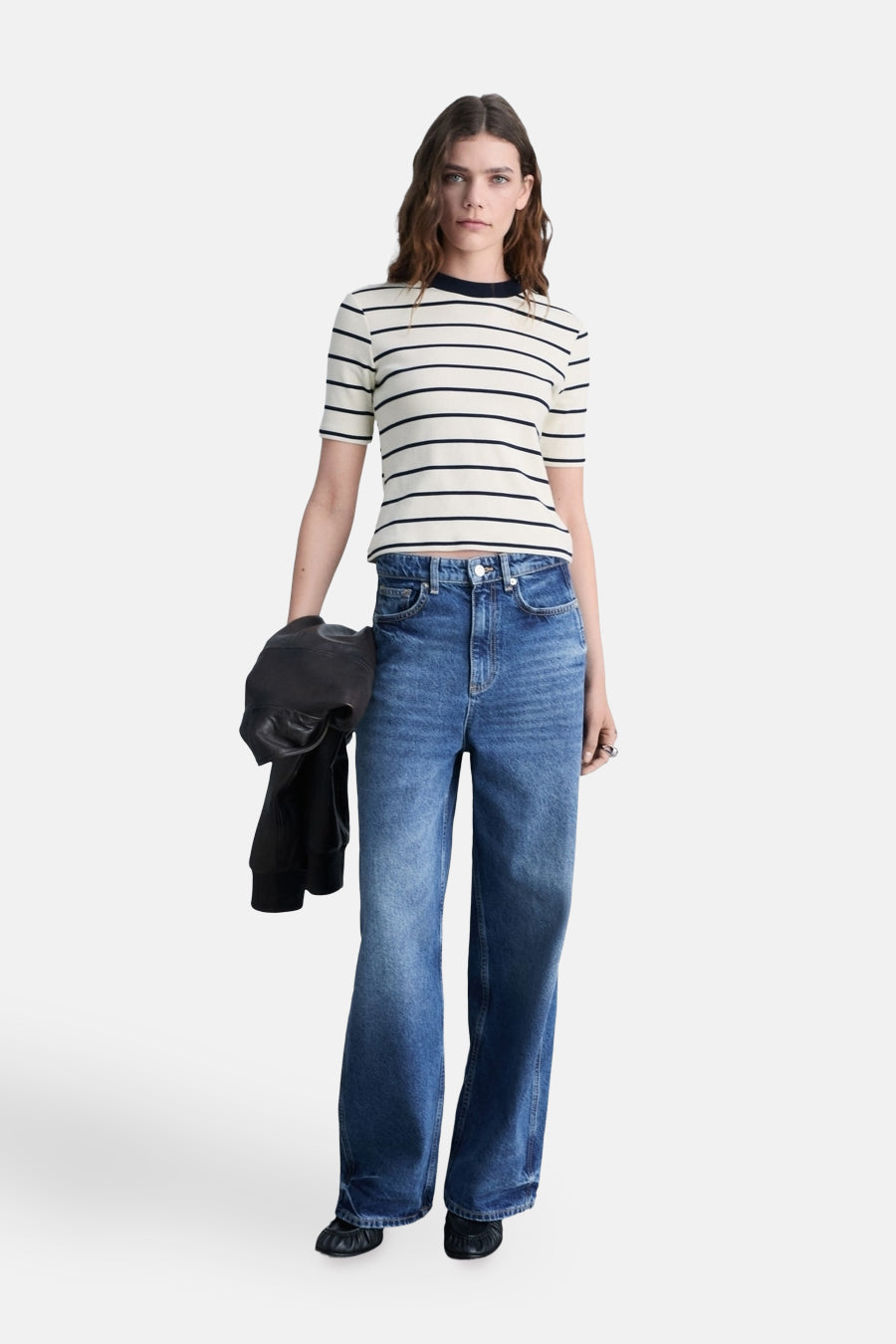 Wit-zwart gestreept T-shirt van MANGO, gedragen met een wijde blauwe jeans en platte schoenen.