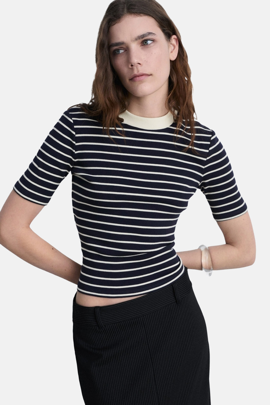 Marineblauw T-shirt met witte strepen van MANGO, gedragen met een zwarte broek met fijne strepen.