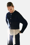 Middelblauwe spijkerblazer van MANGO, gedragen over een witte blouse en een uitlopende broek, met een zwarte handtas.