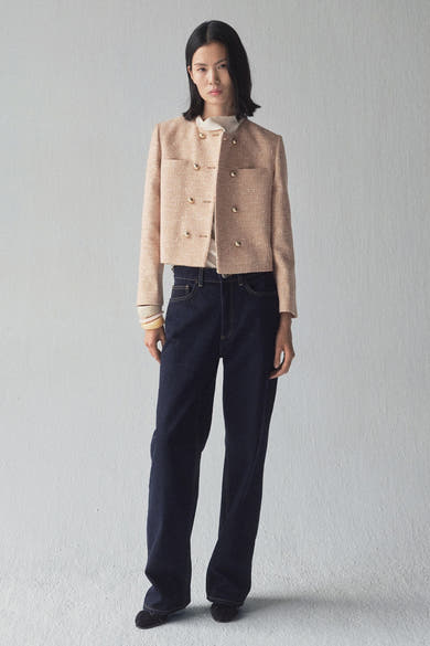 Beige blazer van MANGO, dubbelgeknoopt met gouden knopen, gedragen met een donkerblauwe jeans en zwarte schoenen.