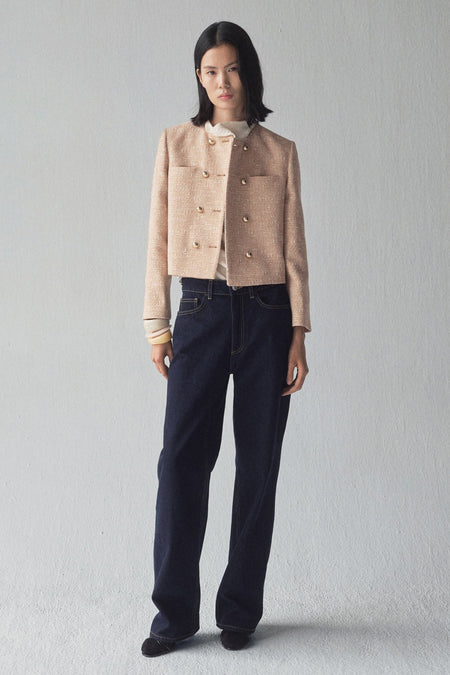 Beige blazer van MANGO, dubbelgeknoopt met gouden knopen, gedragen met een donkerblauwe jeans en zwarte schoenen.