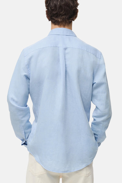 Chemise à manches longues bleue de MANGO, vue de dos, avec détail de pli au milieu du dos.