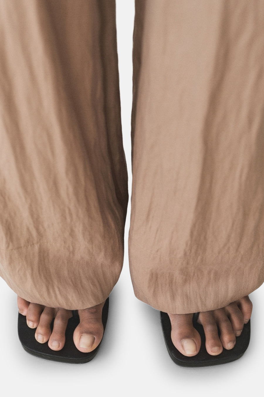 Pantalon brun de MANGO, ample et fluide, porté avec des sandales à bouts carrés noirs.