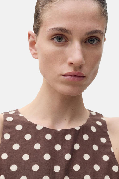 Combinaison marron de MANGO, à pois blancs, portée par une femme cadrée en buste.
