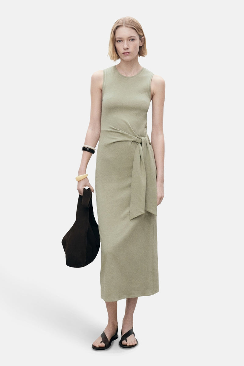 Robe kaki de MANGO avec une ceinture nouée, portée avec des sandales et un sac foncé.
