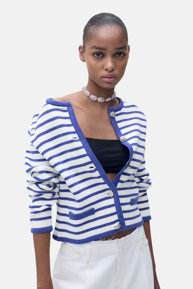Blauwe gestreepte cardigan van MANGO, gedragen met een witte broek met wijde pijpen, achterzicht.