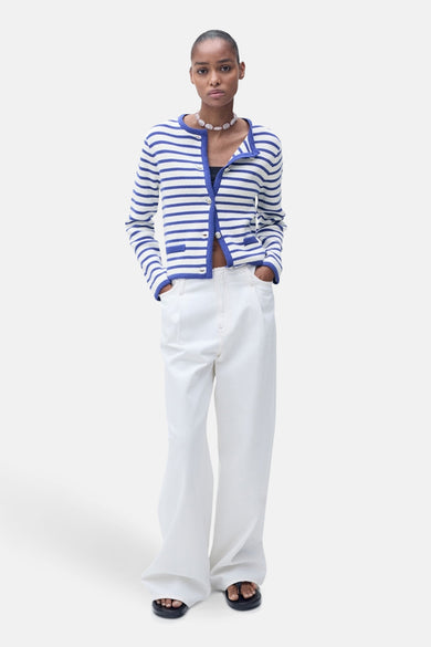 Blauwe gestreepte cardigan van MANGO met contrasterende afwerkingen en decoratieve knopen, gedragen met een witte broek.