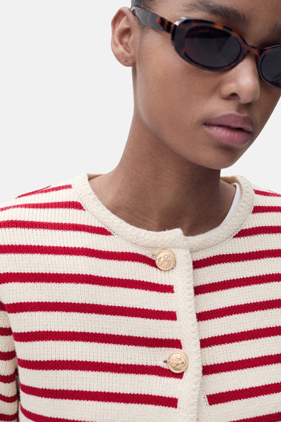 Cardigan rayé en coton rouge et crème de MANGO, avec des boutons dorés décoratifs.