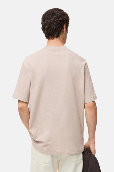 Beige T-shirt met korte mouwen van MANGO, van achteren gedragen met een lichte broek.