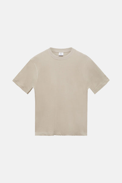 T-shirt beige à manches courtes de MANGO, avec une texture subtile et un col rond simple.
