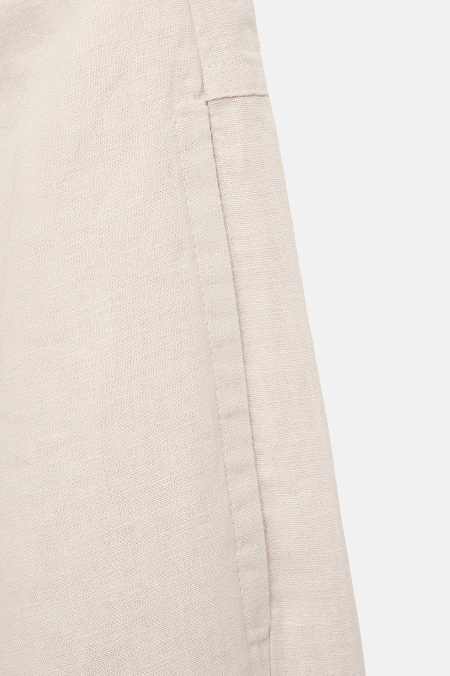 Beige linnen broek van MANGO, detail van de naad en de textuur van de stof.