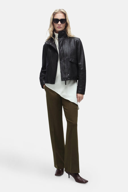 Bruine broek van MANGO, rechte pasvorm, gedragen met een zwart leren jasje en bruine hakken.